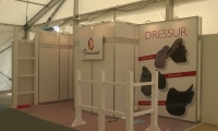 Systembaustand mit eingespannten Bannern und individuell hergestelltem Holzzaun. 