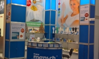 Systemstand mit kassettierter Wand und hinterleuchteten Wandmodulen. Abgehängte Banner vor der Systemwand.