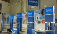 Systemstand mit kassettierter Wand und hinterleuchteten Wandmodulen. Abgehängte Banner vor der Systemwand.