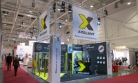 Mischbaustand mit vorgehängten Wänden und eingespannten und hinterleuchteten Bannern. Abgehängte Decke mit abgehängten Bannern. Zudem Individualtheke in X-Form aus Holz gebaut.