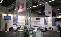 Messestand mit Banner an aufgeständertem Riig auf der Messe ICSE.