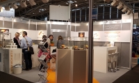 Systemstand mit Digitaldrucken und Vitrinen.