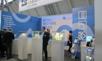 Individualstand aus vorgehängten Wänden mit vollflächigen Digitaldrucken und abgehängten Bannern. Außerdem speziell gefertigter Theke in S-Form mit LED-Beleuchtung.