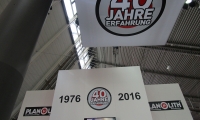 Mischbaustand aus vorgehängten Wänden mit Digitaldrucken und abgehängtem Bannerkubus.
